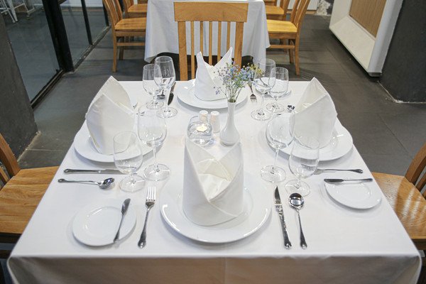 Bàn ăn được bài trí chuyên nghiệp cho bữa tiệc set menu kiểu Âu, thể hiện sự tinh tế trong cách sắp xếp dụng cụ set menu.