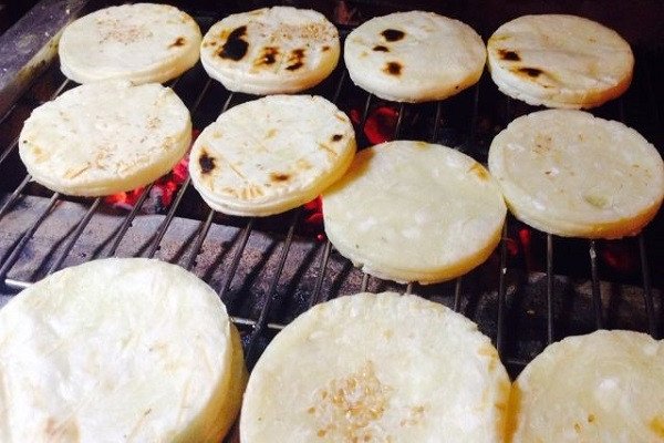 Bánh khoai mì dừa đang được nướng trên bếp than hồng, tạo nên lớp vỏ giòn và hương thơm đặc trưng, hấp dẫn.