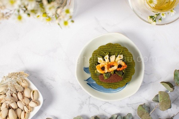 Bánh Trung thu hiện đại hoa 3D với nhiều bông hoa màu sắc rực rỡ, được trang trí tỉ mỉ trên nền bánh trắng.