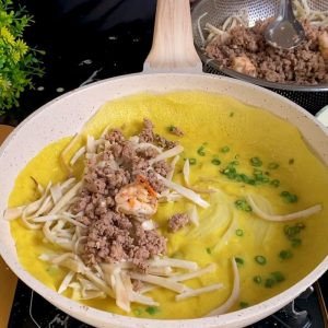 Bánh xèo nhân thịt vịt đang chiên giòn trong chảo