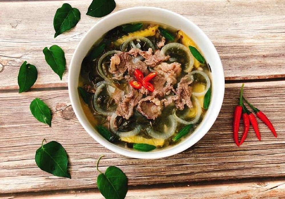 Bát lẩu gầu bò nhúng lá giang nóng hổi với thịt gầu thái mỏng và rau xanh