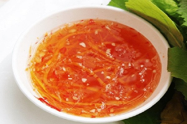Bát nước chấm chua ngọt hoàn hảo cho bánh xèo, với tỏi ớt băm và cà rốt thái sợi.
