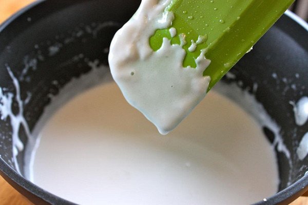 Bát nước cốt dừa sánh mịn, béo ngậy, là phần không thể thiếu để hoàn thiện hương vị thơm ngon của bánh chuối hấp.