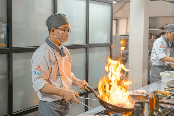 Bếp trưởng đang kiểm tra món ăn chuẩn bị phục vụ thực khách trong nhà hàng sang trọng.