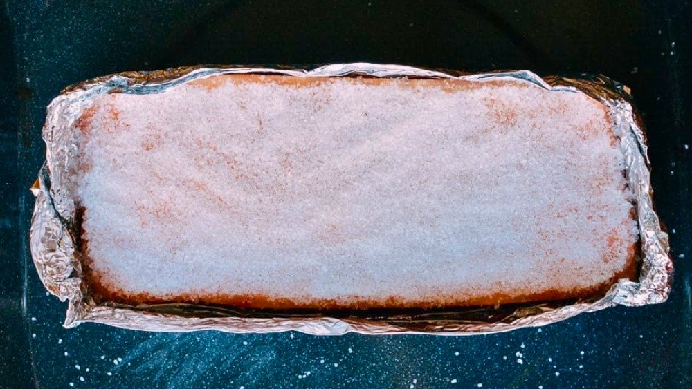 Bọc giấy bạc và phủ muối hạt lên bì heo trước khi nướng.