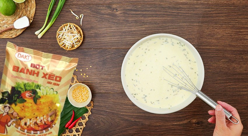 Bột bánh xèo đang được đổ vào chảo nóng tạo vỏ bánh giòn