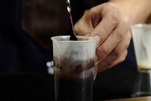 Bột cacao đang được hòa tan đều trong cốc nước nóng