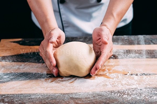 Bột làm bánh bao sữa đang được nhồi mịn màng, sẵn sàng cho công đoạn ủ