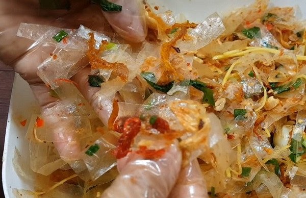 Các nguyên liệu bánh tráng trộn đang được hòa quyện đều trong tô lớn, tạo nên hương vị đặc trưng.