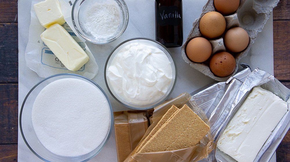 Các nguyên liệu làm bánh cheesecake bao gồm phô mai tươi, kem tươi, trứng, đường và các loại hương liệu đang được trộn đều