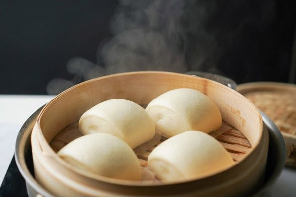 Cách đặt bánh bao sữa lên giấy nến trước khi hấp