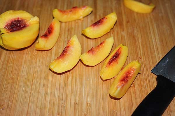 Cắt đào tươi thành miếng nhỏ để ngâm làm trà đào