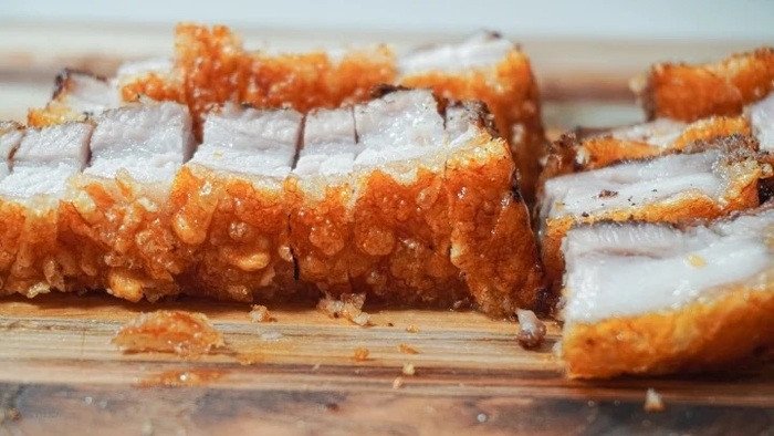 Cắt thịt heo quay thành miếng vừa ăn để thưởng thức trọn vẹn hương vị