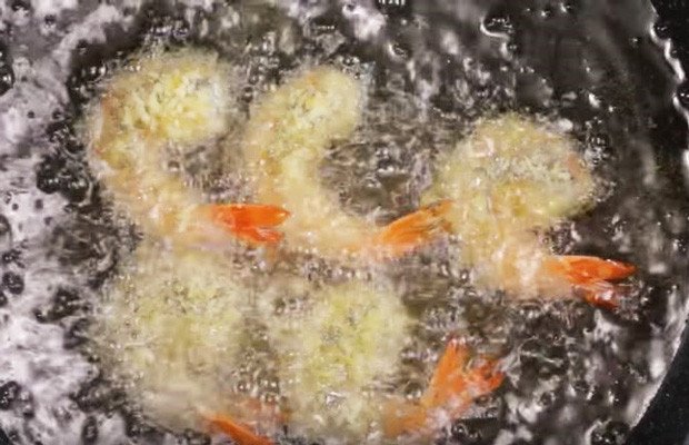 Chảo dầu nóng già với những con tôm tẩm bột chiên xù đang được chiên vàng giòn