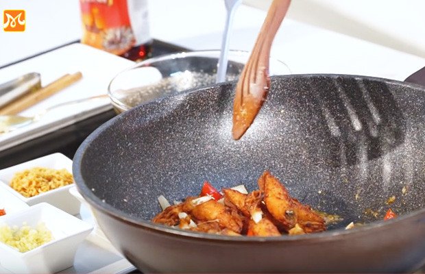 Chảo mực đang được xào đều với nước sốt nước mắm thơm lừng, hấp dẫn