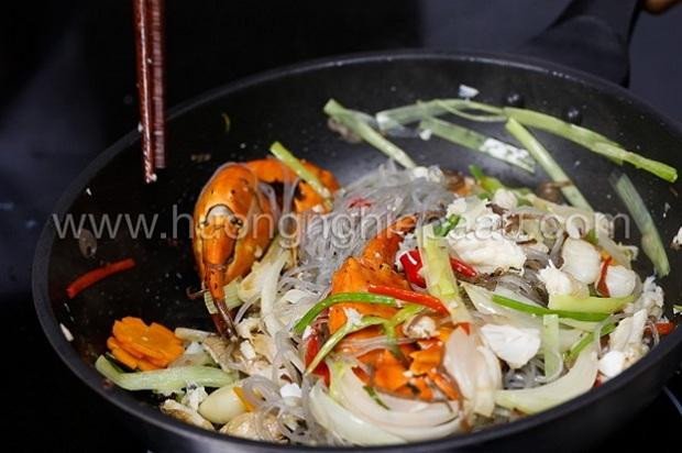 Chế biến miến xào cua trên chảo lớn để các nguyên liệu hòa quyện