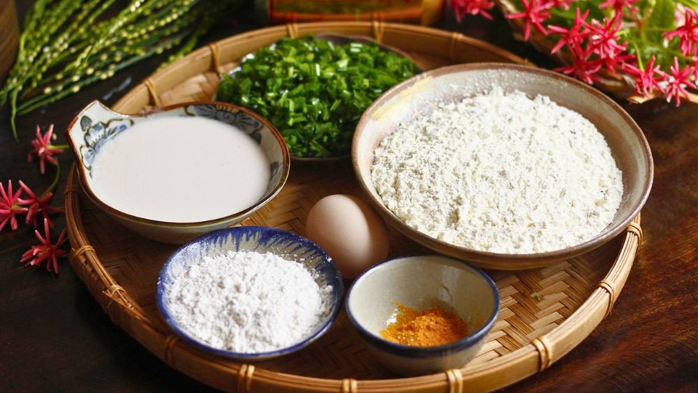 Chiếc bánh xèo đang được chiên giòn trong chảo, minh họa khả năng ứng dụng đa dạng của bột bánh xèo DAKI trong các món ăn truyền thống.
