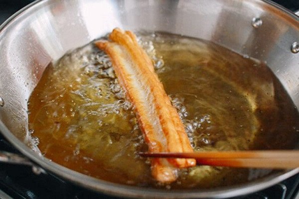 Chiên bánh quẩy ngập dầu cho vàng giòn.