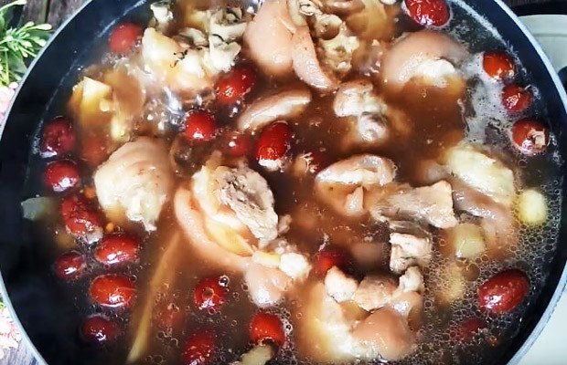 Cho giò heo và các nguyên liệu thuốc bắc vào nồi áp suất để hầm kỹ, đảm bảo thịt mềm ngon