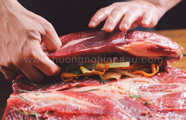 Cuộn nhân rau củ vào khối thịt bò để làm bò nướng tảng