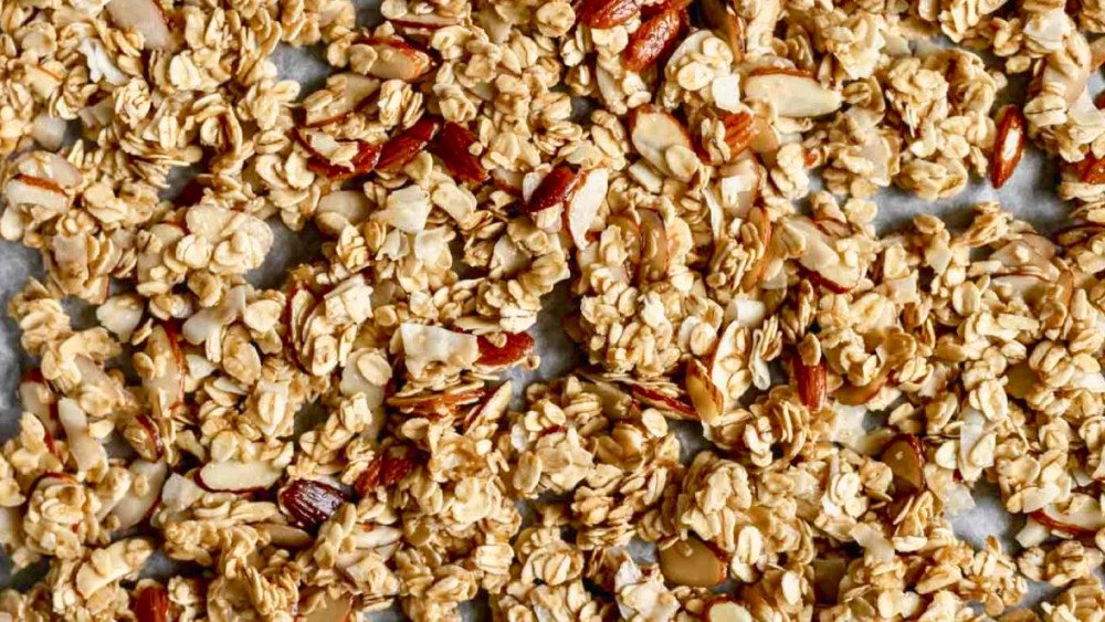 Dàn đều granola trên giấy nến trong nồi chiên không dầu để nướng