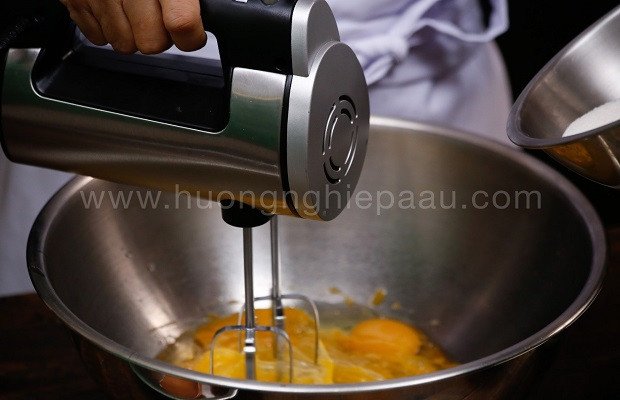 Đánh trứng gà và đường để làm cốt bánh bông lan Mousse dâu tây