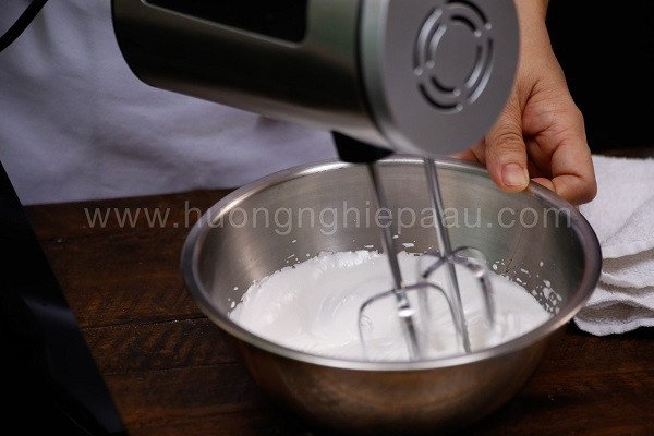 Đánh whipping cream đến khi bông cứng để làm kem cho bánh bông lan cuộn