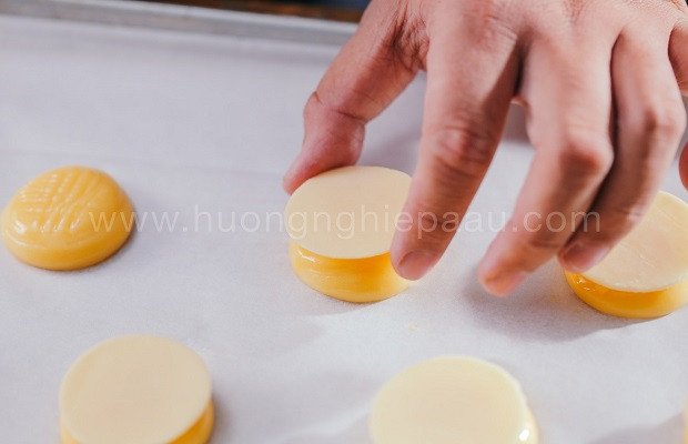 Đặt lớp topping cookie giòn rụm lên vỏ bánh su kem trà xanh