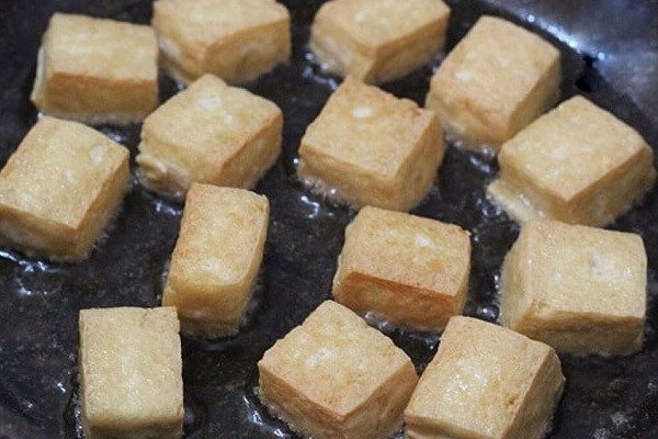 Đậu phụ chiên vàng giòn trong chảo dầu nóng