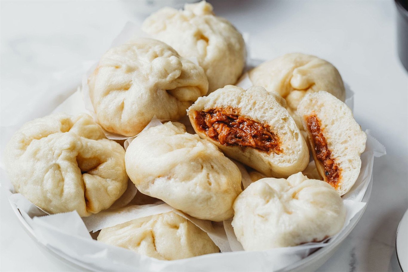 Đĩa bánh bao nóng hổi, mềm xốp sau khi hấp thành công bằng nồi chiên không dầu, sẵn sàng thưởng thức