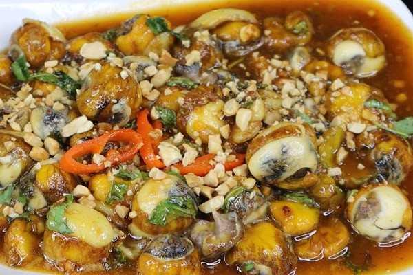 đĩa trứng cút lộn xào me đã hoàn thành, rắc thêm rau răm và đậu phộng rang