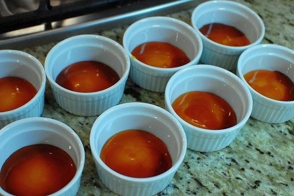 Đổ caramel màu vàng cánh gián sánh mịn vào khuôn làm bánh flan cà phê