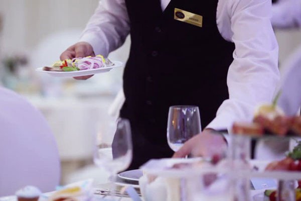 Đội ngũ nhân viên chuyên nghiệp đang chuẩn bị và phục vụ tiệc banquet trong không gian sang trọng.