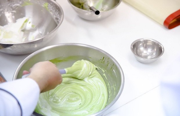 Đôi tay nhẹ nhàng trộn đều hỗn hợp bột bánh bông lan trà xanh để giữ độ xốp và mịn, đảm bảo bánh nở đẹp