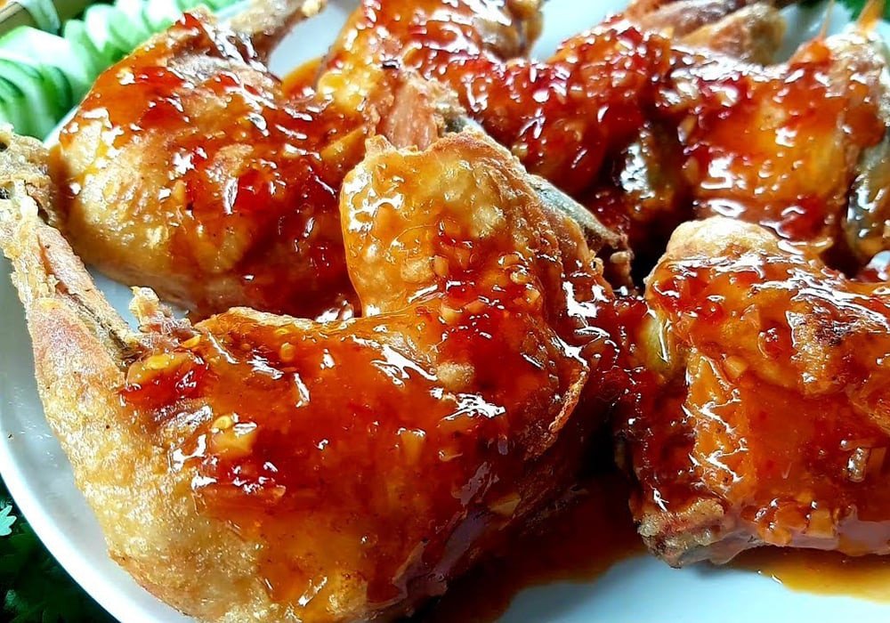 Đùi gà chiên mật ong với lớp da nâu óng, phủ mè rang