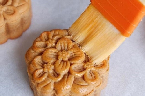 Dùng cọ lông mềm quét đều hỗn hợp trứng và sữa lên mặt bánh trước khi nướng lần hai để bánh có màu vàng đẹp