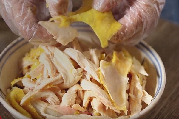 Gà luộc vàng óng và thịt gà xé sợi chuẩn bị làm gỏi