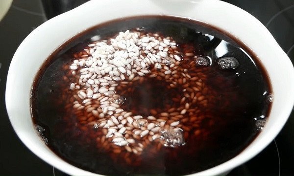 Hạt gạo nếp đang được ngâm trong nước luộc đỗ đen để tạo màu sắc tự nhiên cho xôi