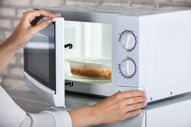 Hình ảnh minh họa việc sử dụng an toàn nồi chiên không dầu và lò vi sóng trong gian bếp.