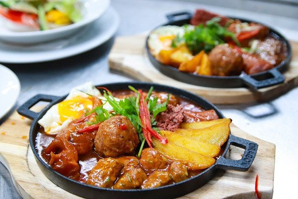 Hình ảnh tổng thể một suất bánh mì chảo đa dạng topping cùng bánh mì giòn.