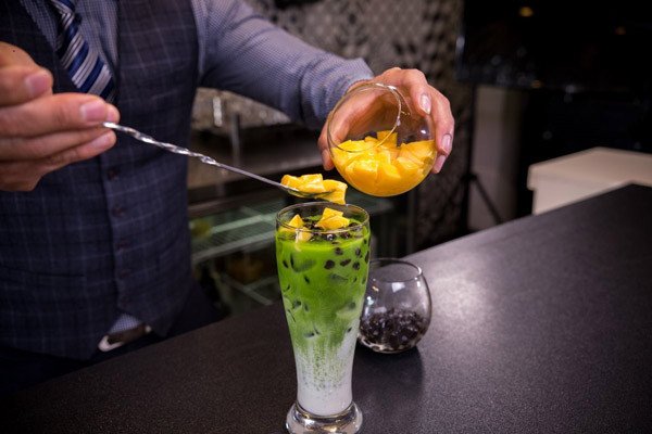 Hoàn thành ly sữa tươi matcha trân châu pudding trứng với topping trân châu và pudding