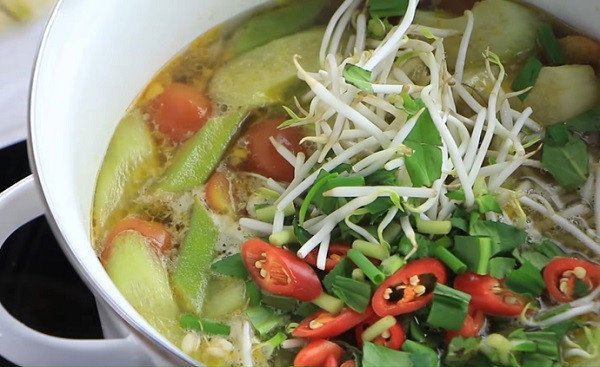 Hoàn thành món canh chua cá diêu hồng với rau và gia vị