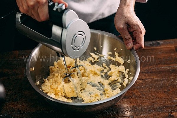 Cách Làm Bánh Quy Hạnh Nhân Giòn Thơm Chuẩn Vị Hỗn hợp bơ đường và trứng đang được đánh mịn để chuẩn bị làm bánh quy hạnh nhân