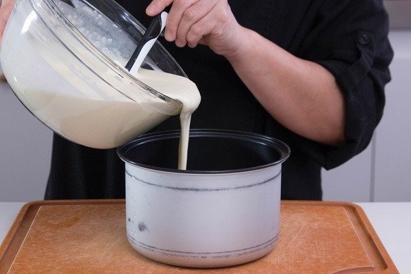 Hỗn hợp bột bánh khoai mì đã chuẩn bị được đổ vào lòng nồi cơm điện, sẵn sàng cho phương pháp nướng tiện lợi và nhanh chóng.