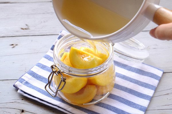 Hũ đào ngâm đang được đặt ở nơi khô ráo, minh họa cách bảo quản đào ngâm đúng cách