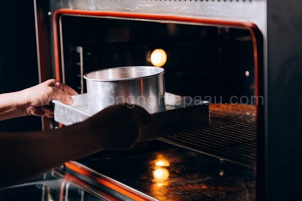 Khay bánh gato được cho vào lò nướng để tạo ra chiếc bánh bông lan vàng óng