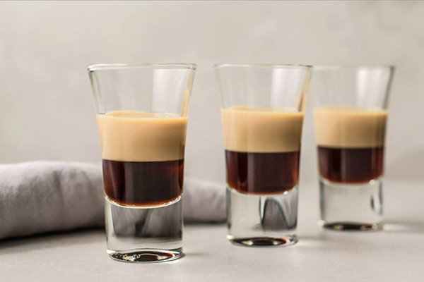 Kỹ thuật pha chế Cocktail B52, rót chậm rãi lớp Baileys Irish Cream bằng bar spoon để tạo tầng rõ nét