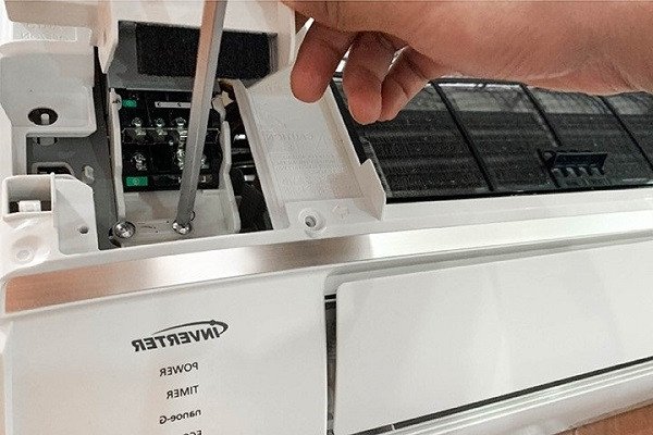 Kỹ thuật viên đang thực hiện mở hộp điện dàn nóng để đấu nối dây điện điều hòa 2 chiều an toàn