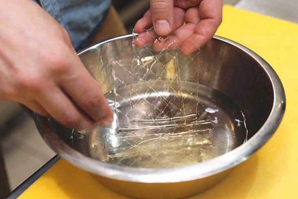 Lá gelatin ngâm nở trong nước, chuẩn bị cho bánh mousse trà xanh