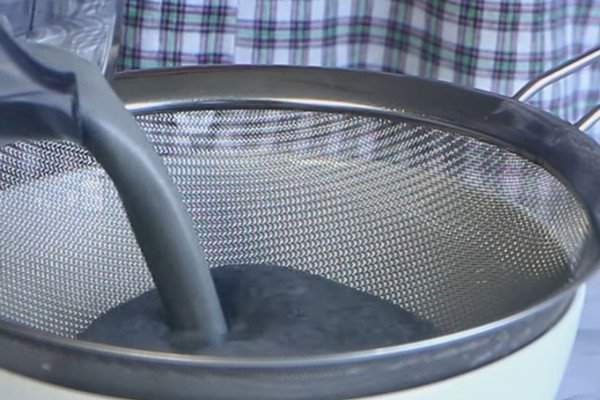Lọc hỗn hợp mè đen đã xay để có được nước cốt mè đen mịn, không cặn cho chè